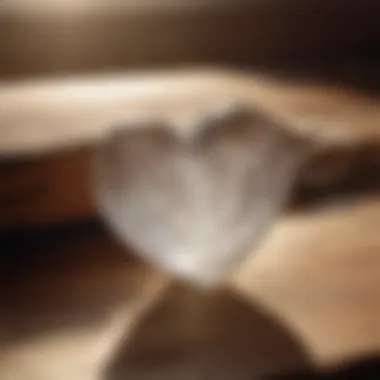 Selenite heart placed on a wooden surface with soft lighting enhancing its glow